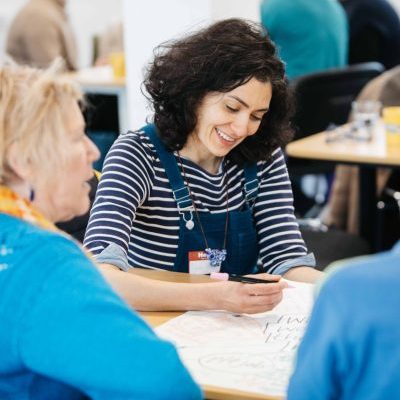 Woman writing in a creative health network meeting