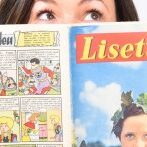 Lisette, white with freckles and brown hair, peers over the top of an open colourful French comic, the title of which is Lisette.